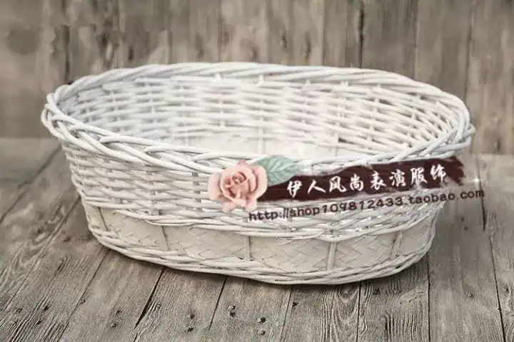 سلة خيزران بيضاء لتصوير المواليد مزينة بوردة زهرية جانبية