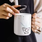 كوب سيراميك أبيض مع غطاء أسود رسمة نبتة ونجوم ذهبية