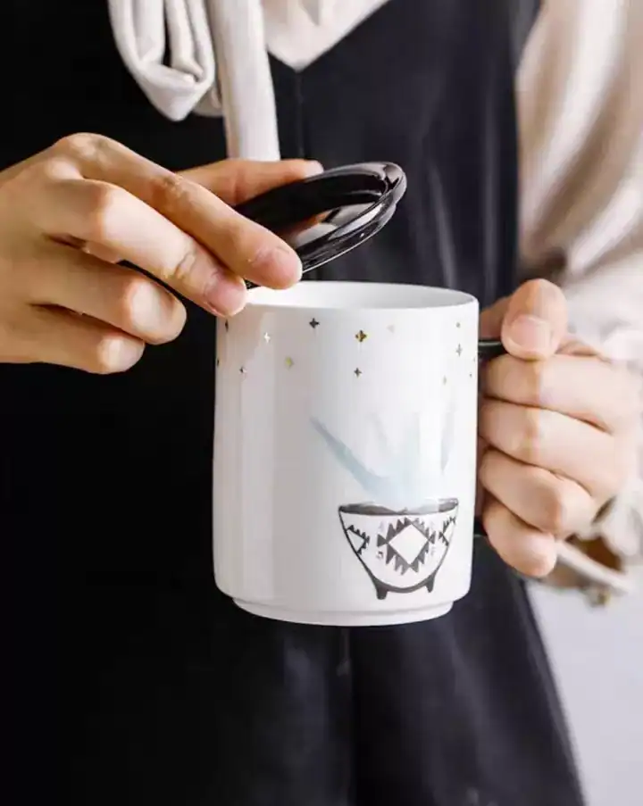 كوب سيراميك أبيض مع غطاء أسود رسمة نبتة ونجوم ذهبية