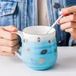 كوب قهوة سيراميك أزرق سماوي بنقوش أوراق ذهبية وحافة مذهبة