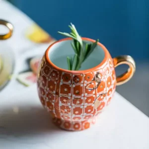 كوب قهوة سيراميك برتقالي مزخرف بمقبض ذهبي سعة 300 مل
