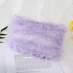 مخدة تصوير مواليد من الدانتيل الأبيض الفاخر بتصميم مستطيل موضوعة على خلفية قماشية ناعمة في استوديو تصوير مواليد