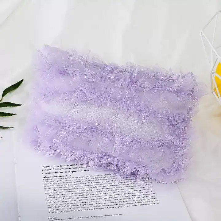 مخدة تصوير مواليد من الدانتيل الأبيض الفاخر بتصميم مستطيل موضوعة على خلفية قماشية ناعمة في استوديو تصوير مواليد