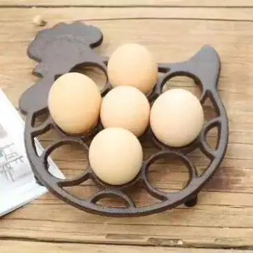حامل بيض معدني على شكل دجاجة باللون البرونزي العتيق يضم 5 بيضات موضوع على طاولة خشبية بتصميم ريفي أنيق
