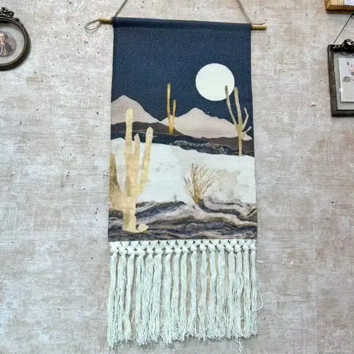 ديكور جداري قماش بمشهد طبيعي مطبوع لصحراء وجبال وصبار تحت ضوء القمر على خلفية ليلية مع شراريب مكرمية يدوية