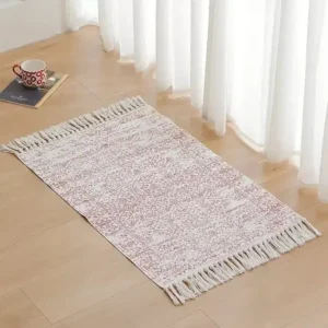 دعاسات قماشية مودرن باللون الرمادي المزرق مع أهداب بيج موضوعة بجانب سرير في غرفة نوم عصرية بتصميم هادئ