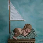 سرير تصوير مواليد خشبي على شكل قارب شراعي مع علم ابيض ثيم بحري