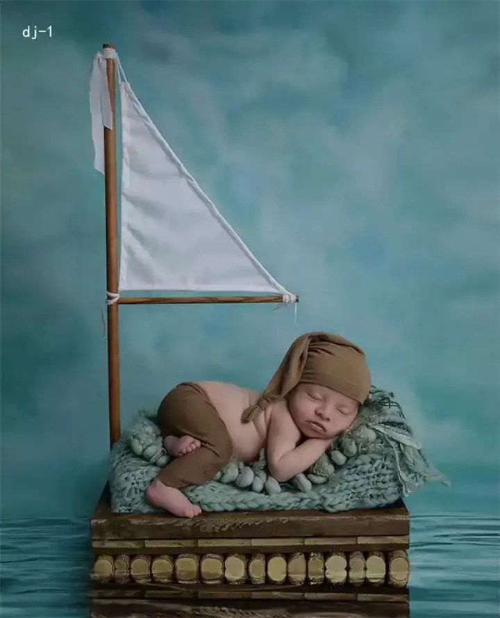 سرير تصوير مواليد خشبي على شكل قارب شراعي مع علم ابيض ثيم بحري