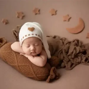 مخدة صوف حجم كبير بتصميم محبوك باللون السماوي والرمادي والوردي تستخدم كقاعدة دعم مريحة لتصوير المواليد حديثي الولادة