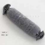 مخدة صوف حجم كبير بتصميم محبوك باللون السماوي والرمادي تستخدم كقاعدة دعم مريحة لتصوير المواليد حديثي الولادة