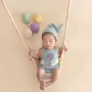 مجموعة بوالين قماشيه ملونة بألوان باستيل (أصفر، أزرق، ليلكي) تستخدم كإكسسوار لتصوير المواليد فوق أرجوحة ناعمة