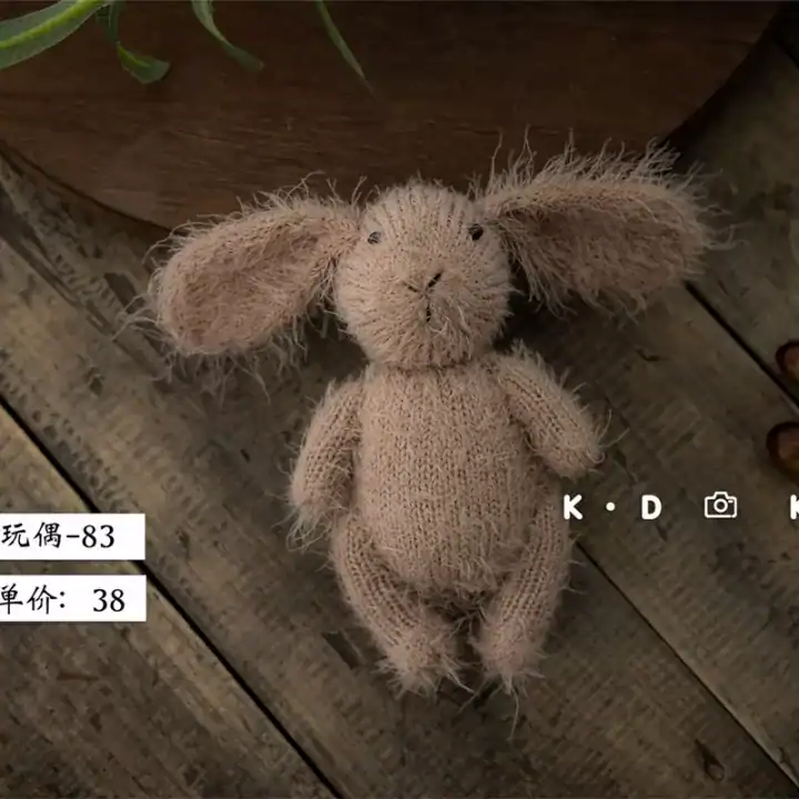 دمية أرنب كروشيه بني فاتح محبوكة يدوياً بآذان طويلة لتصوير المواليد وحديثي الولادة بأسلوب فني دافئ