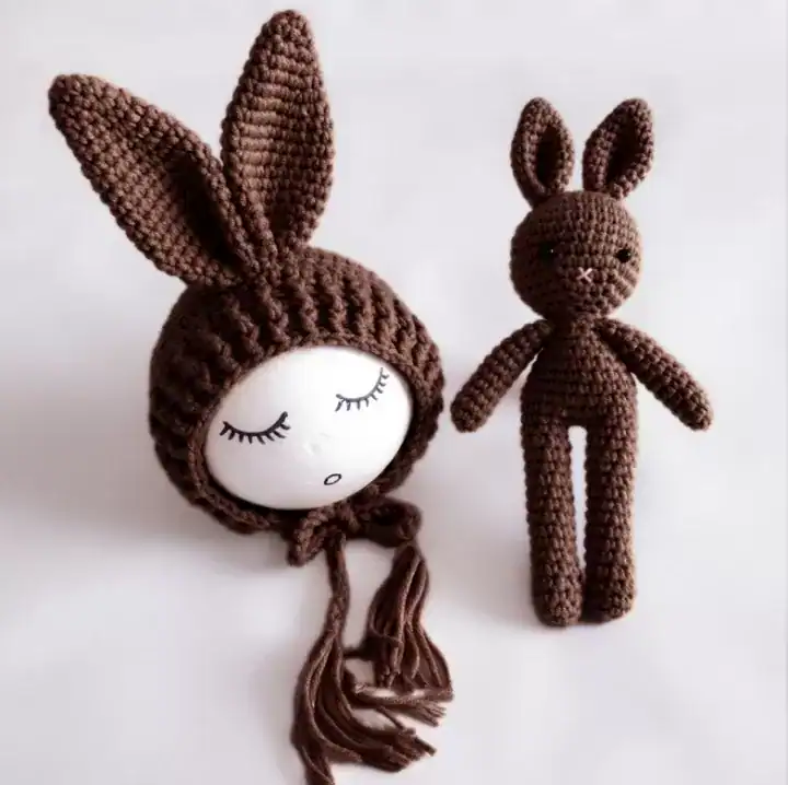 طقم كروشيه أرنب أبيض محبوك يدوياً يتكون من قبعة ودمية لتصوير المواليد وحديثي الولادة بأسلوب فني لطيف