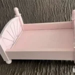 سرير خشبي لون وردي فاتح بلاش لتصوير المواليد تصميم شابي شيك
