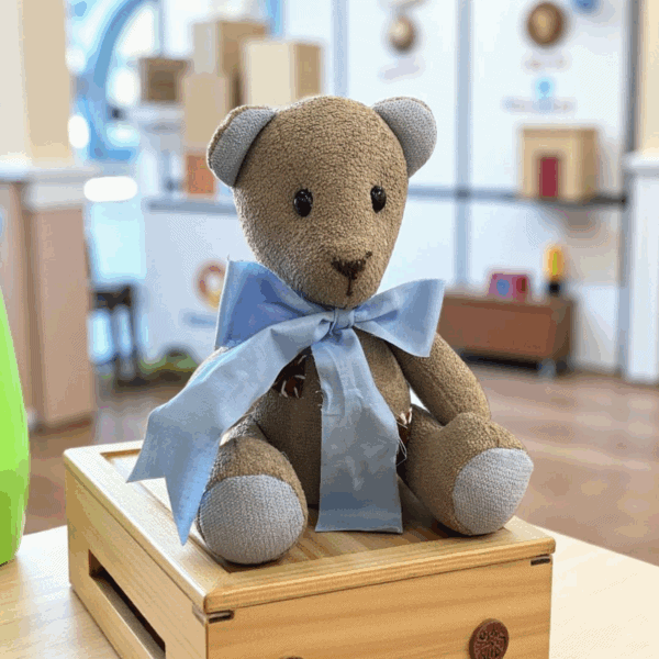 دبدوب قماشي صناعة يدوية لون بني مع فيونكة زرقاء كبيرة ديكور غرف مواليد