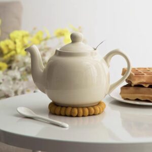 ابريق شاي مفرد ماركة London Pottery لون كريمي عاجي مع فلتر ستانلس ستيل بجانب طبق وافل