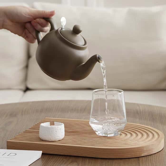 ابريق شاي مفرد ماركة London Pottery لون بني موكا مطفي يصب الماء في كوب زجاجي