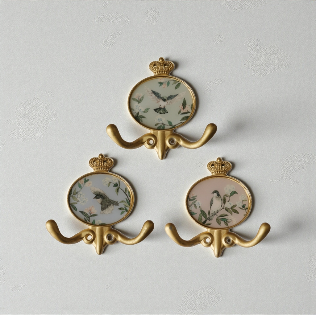 علاقة جدارية ذهبية بتصميم تاج واطار بيضاوي ورسومات طيور للمداخل